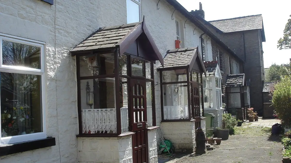 Stone cottages with porches and white-framed windows on Park View, Bolton