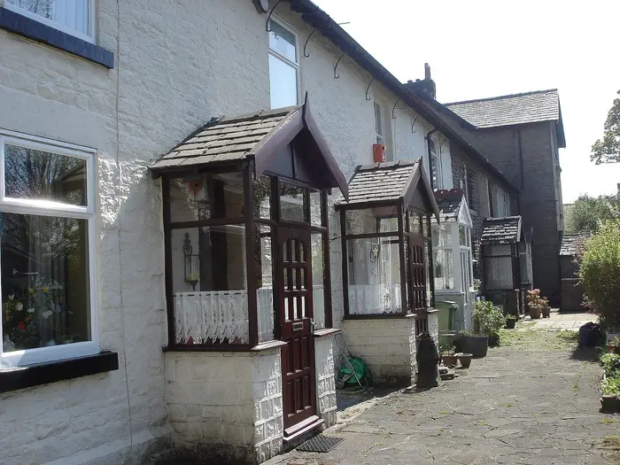 Stone cottages with porches and white-framed windows on Park View, Bolton