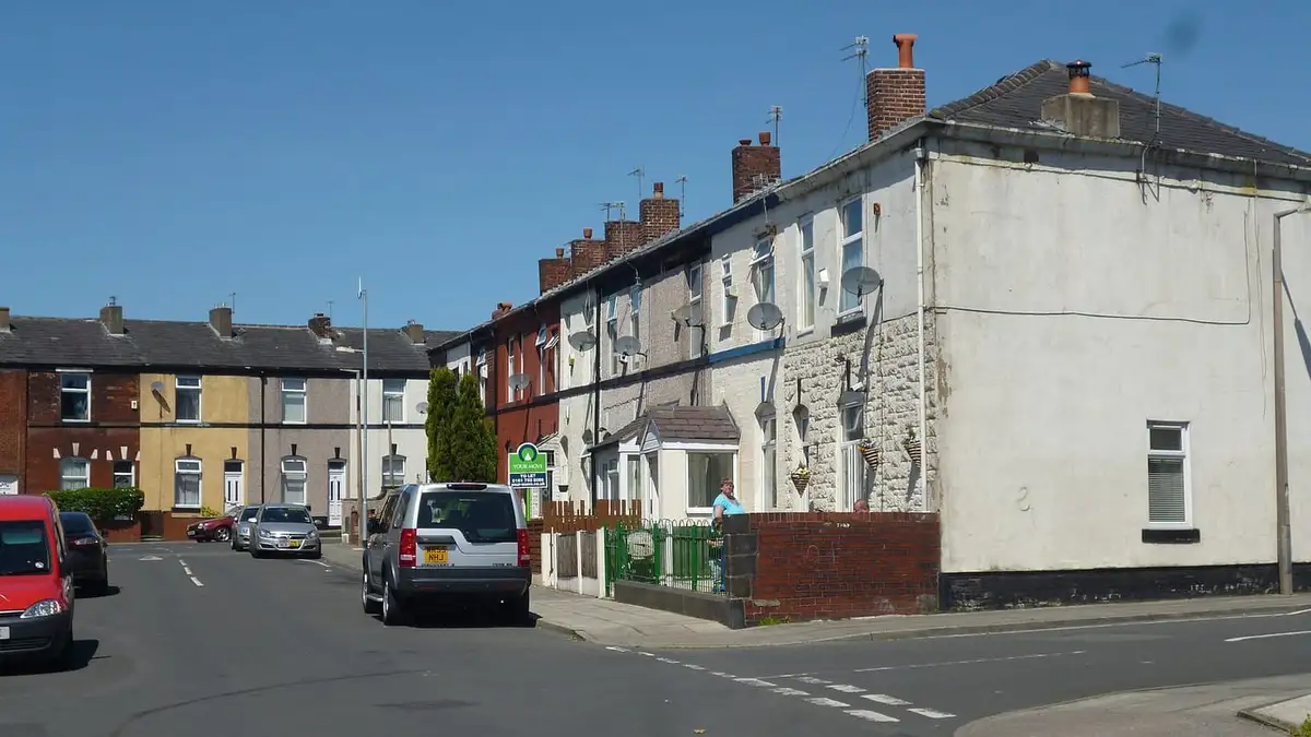 Painted terraced houses on Laurel Street, Bury, under a blue sky