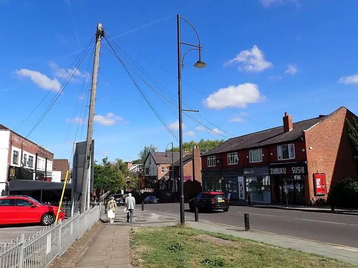 Shops on Station Road in Cheadle Hulme village centre on a sunny day