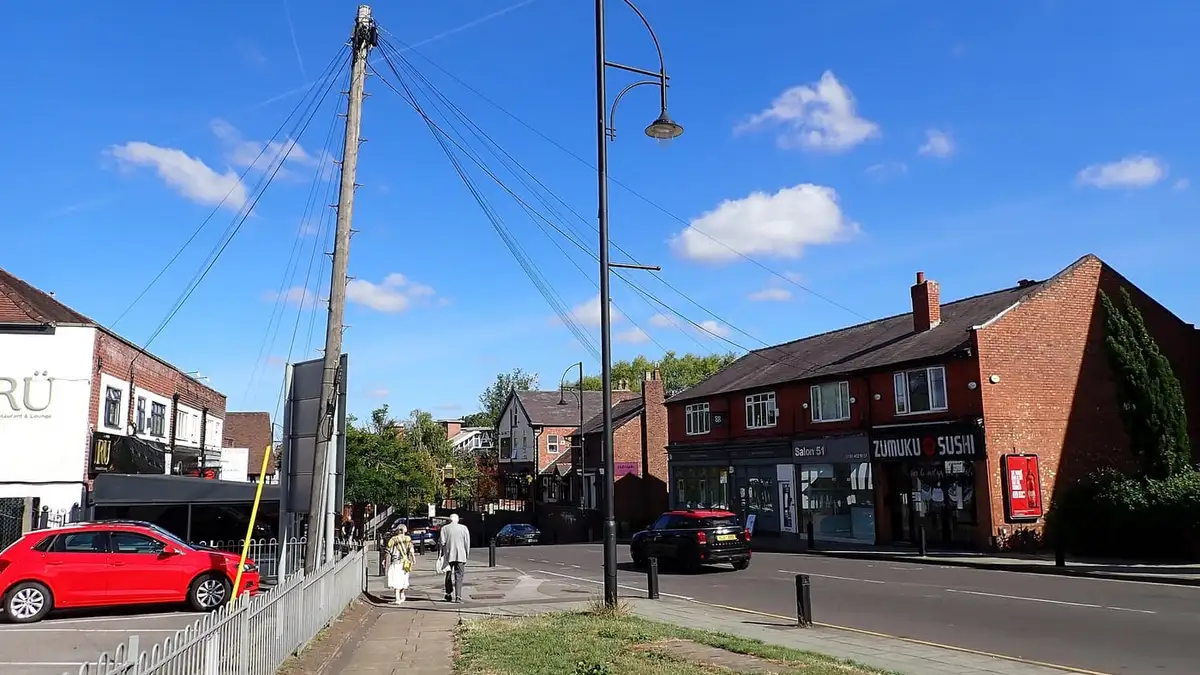 Shops on Station Road in Cheadle Hulme village centre on a sunny day