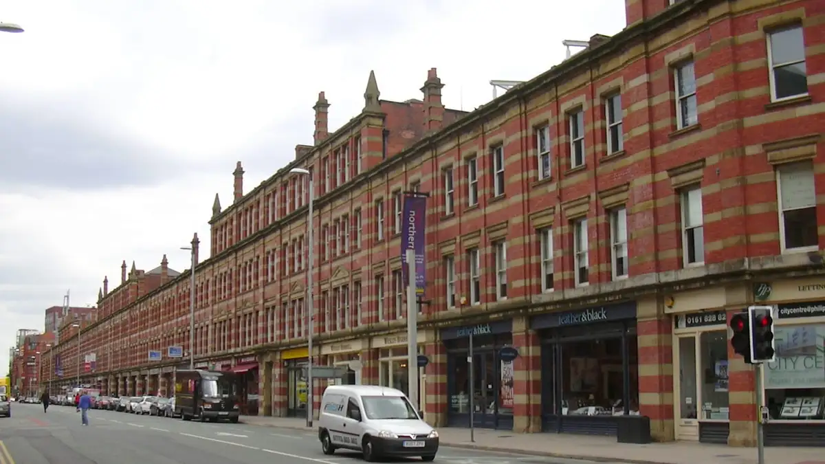 Long Victorian red-brick parade of shops and offices along Deansgate, Manchester