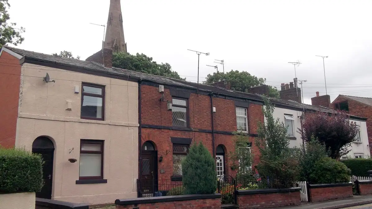 Brick cottages on Pole Lane near Failsworth Pole, with church spire