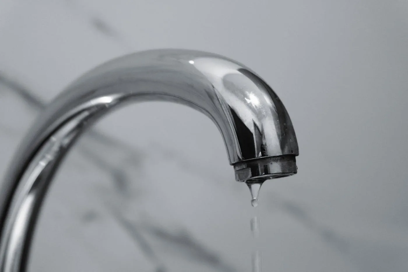 Chrome tap with water dripping from the spout