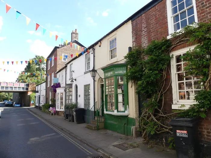 Historic brick and painted shops along King Street, Knutsford, with bunting