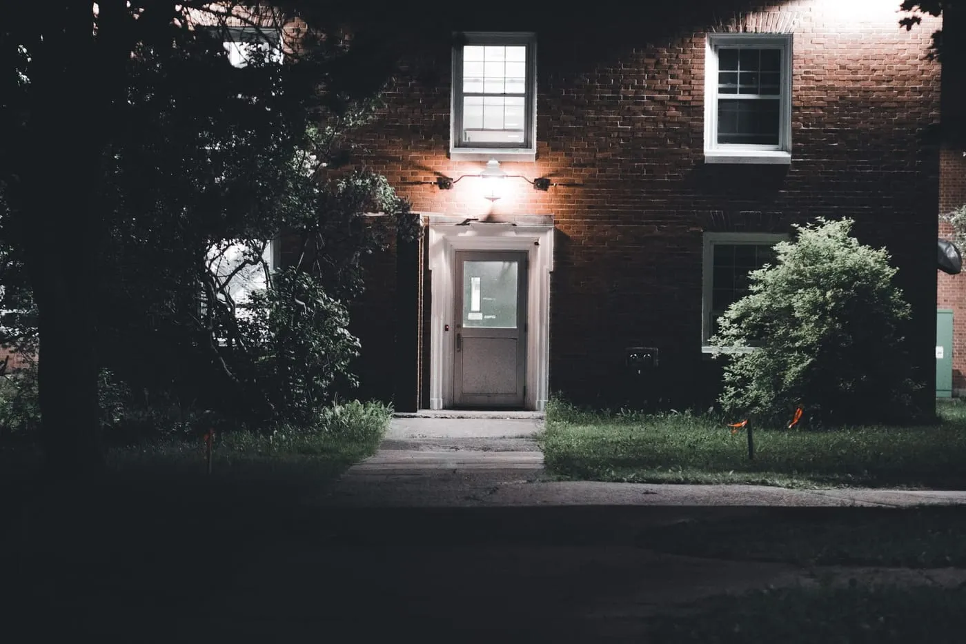 Brick house front door lit by an outside light at night