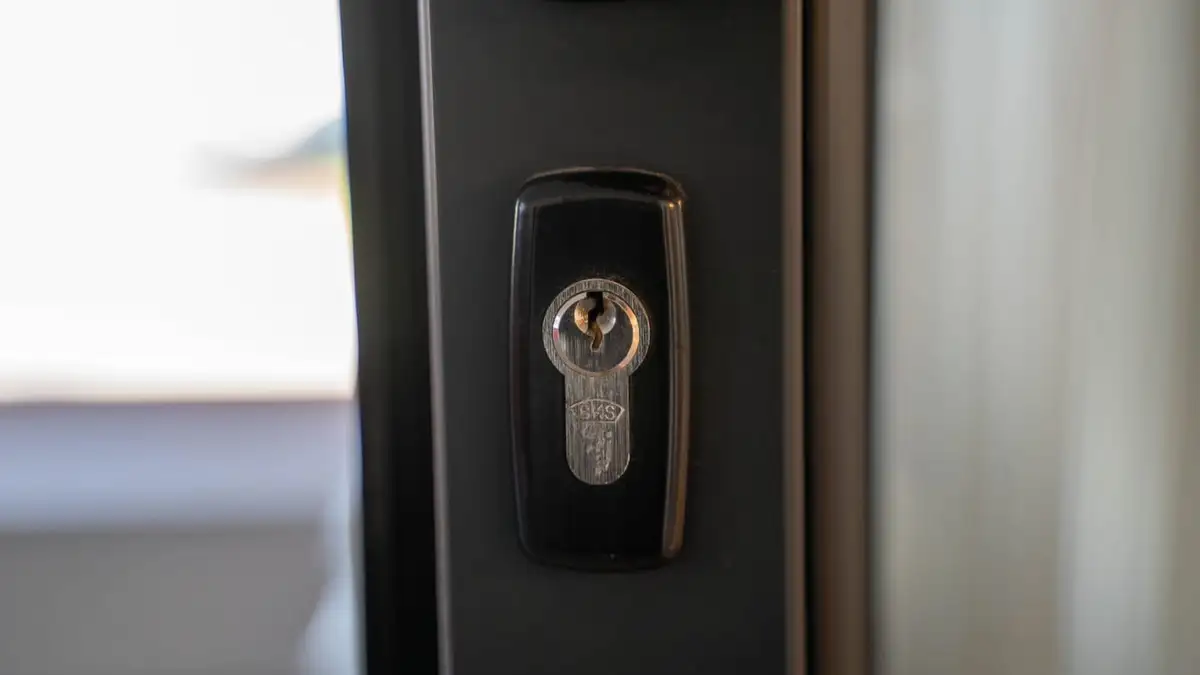 Euro cylinder lock and keyhole in a dark front door edge