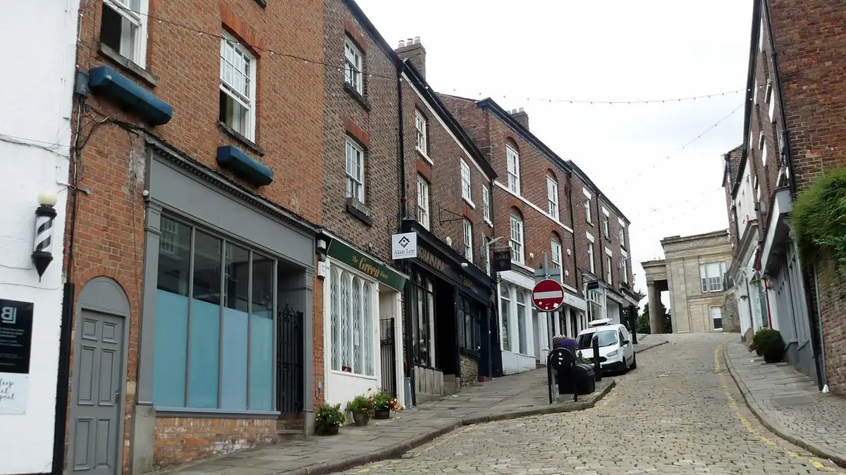Listed brick shops on cobbled Church Street, Macclesfield town centre
