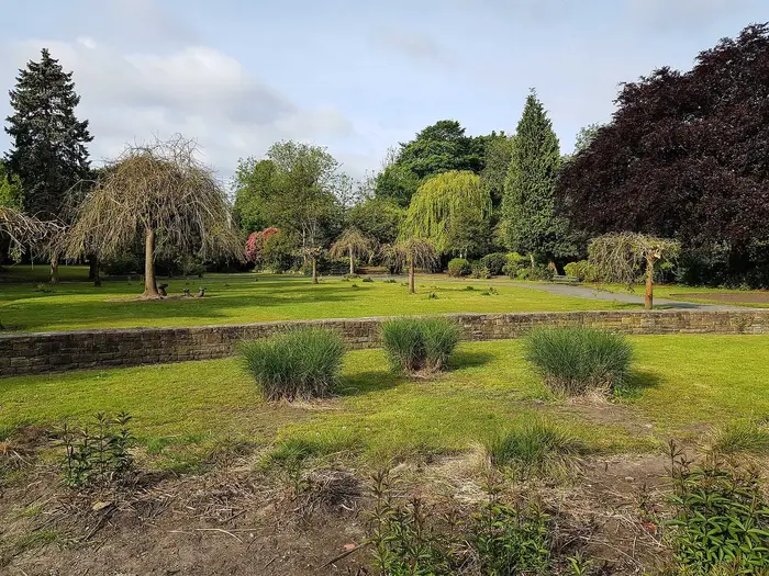 Trees and lawns in Longford Park, Stretford, on a sunny day