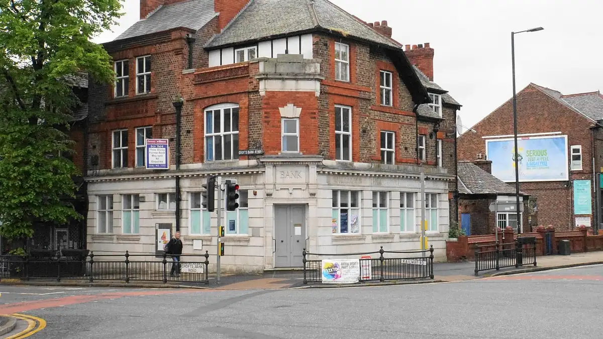 Red-brick former bank building on a corner in Urmston town centre