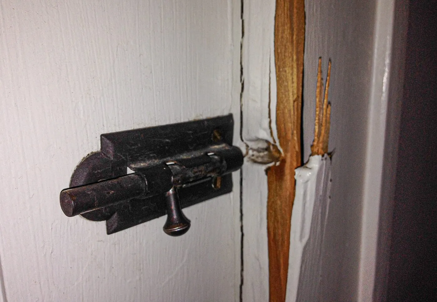 Door bolt torn from a split wooden door frame after a forced entry