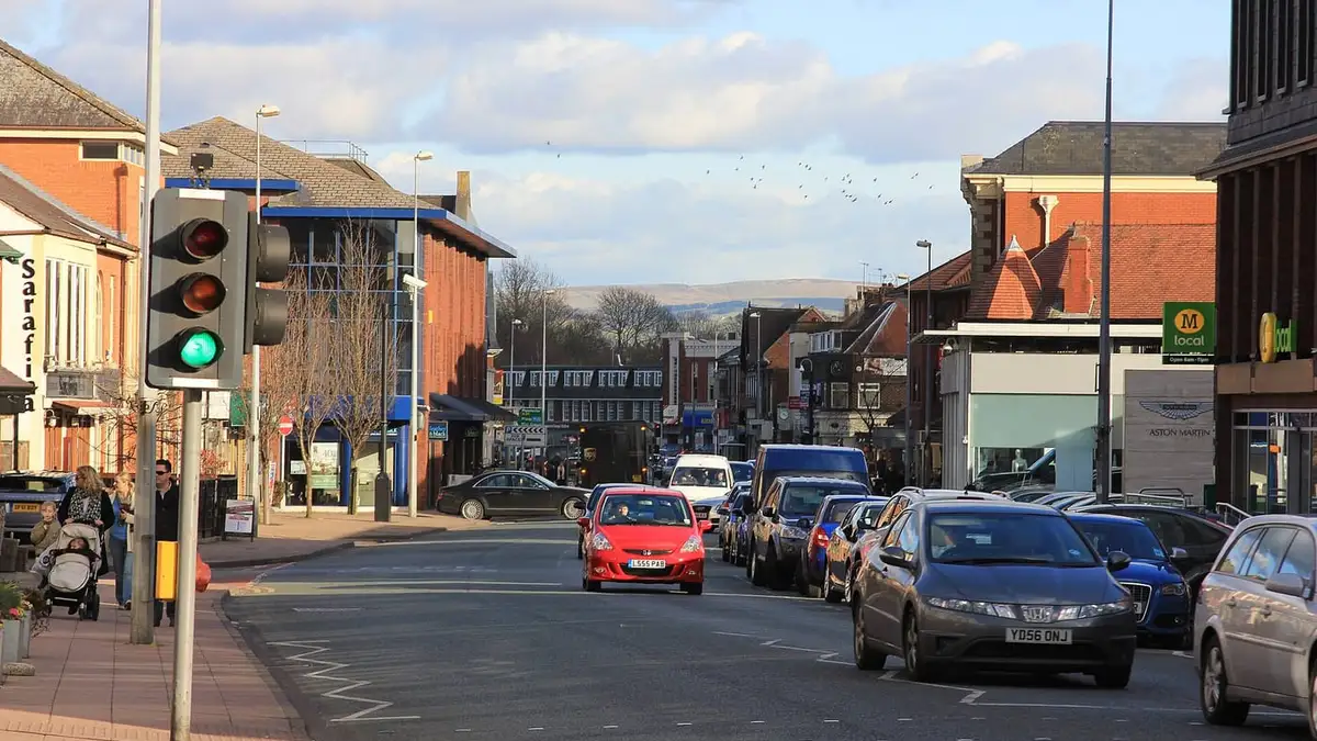 Shops and traffic on Water Lane in Wilmslow town centre, Cheshire