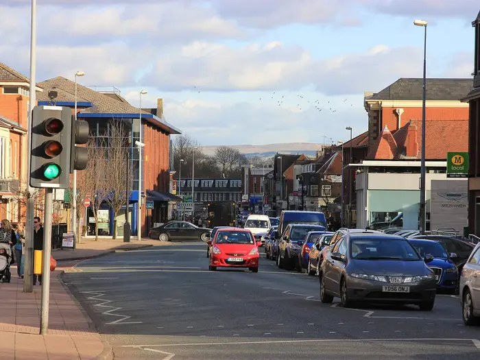 Shops and traffic on Water Lane in Wilmslow town centre, Cheshire