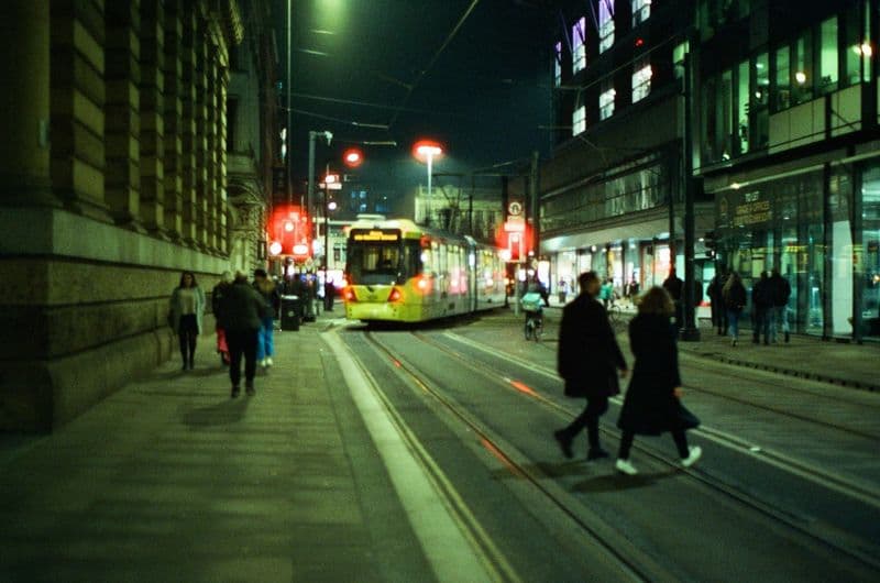 City street at night with people on the pavement