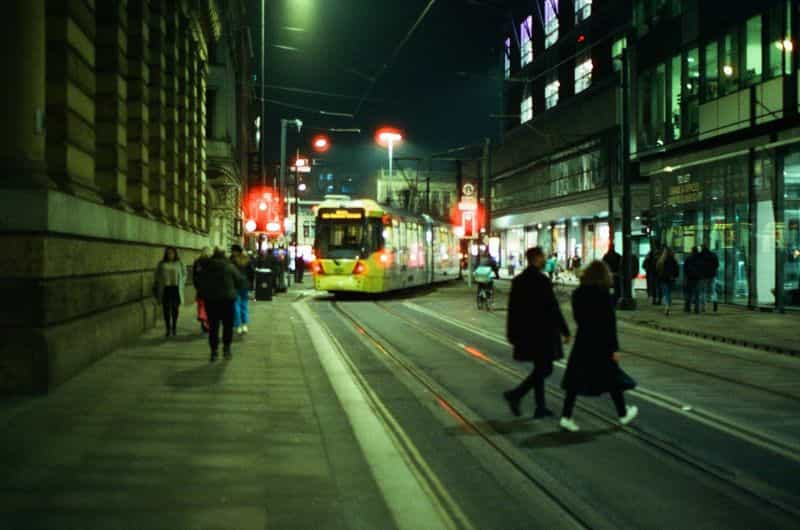 City street at night with people on the pavement